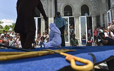 Une Indonésienne se fait flageller en public par la police de la Charia à Banda Aceh, le 20 mars 2019. Illustration. (Crédit : CHAIDEER MAHYUDDIN / AFP)
