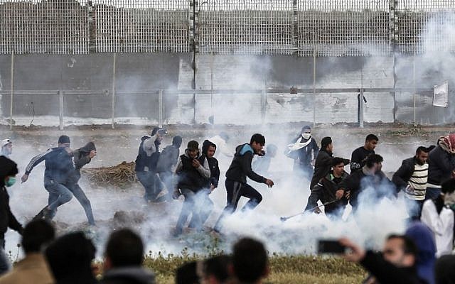 Des manifestants palestiniens fuient les grenades lacrymogènes tirées par les forces israéliennes lors d'affrontements au milieu d'une manifestation de masse marquant le premier anniversaire de la Marche du retour, près de la frontière avec Israël à l'est de la ville de Gaza, le 30 mars 2019. (Mahmud Hams/AFP)