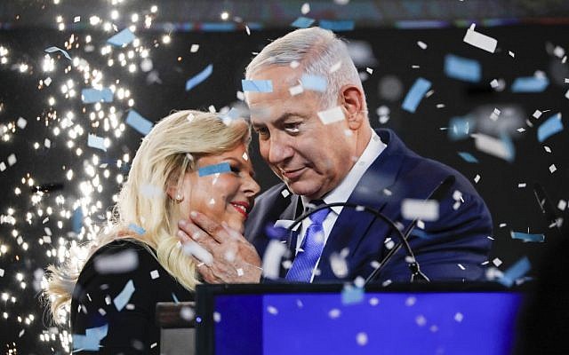 Le Premier ministre Benjamin Netanyahu embrasse son épouse Sara au milieu des confettis lors de son discours de victoire devant des sympathisants au siège du Likud à Tel Aviv, après les élections du 9 avril 2019. (Thomas Coex/AFP)