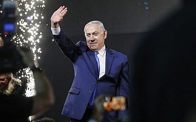 Le Premier ministre Benjamin Netanyahu salue les partisans au siège du parti du Likud, dans la ville côtière de Tel Aviv, lors de la soirée électorale dans la nuit du 10 avril 2019 (Crédit : Thomas Coex / AFP).