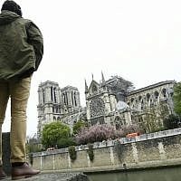 Un homme regarde l'état de la cathédrale Notre-Dame de Paris au lendemain d'un incendie, le 16 avril 2019. (Crédit : Bertrand GUAY / AFP)