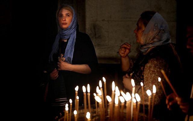 Des chrétiens orthodoxes prient dans l'église du saint-sépulcre après avoir célébré le vendredi saint par une procession dans la Via Dolorosa dans la Vieille ville de Jérusalem, le 26 avril 2019 (Crédit : THOMAS COEX / AFP)