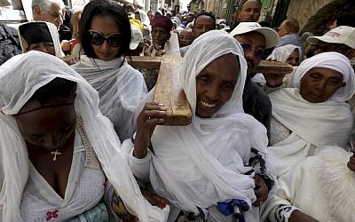 Des pèlerins orthodoxes éthiopiennes transportent une croix dans la Via Dolorosa au cours d'une procession organisée pour le vendredi saint par les chrétiens orthodoxes dans la Vieille Ville de Jérusalem, le 26 avril 2019 (Crédit : PHOTO/GALI TIBBON (Photo by GALI TIBBON / AFP)
