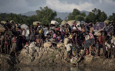 Des réfugiés rohingyas attendent après avoir traversé le fleuve Naf du Myanmar au Bangladesh à Whaikhyang, le 9 octobre 2017. (AFP PHOTO / FRED DUFOUR)