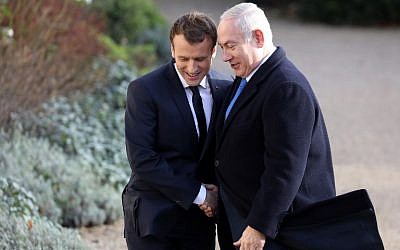 Le président français Emmanuel Macron, à gauche, serre la main du Premier ministrte Benjamin Netanyahu à son arrivée au palais de l'Elysée à Paris, le 10 décembre 2017 (Crédit :   / AFP PHOTO / ludovic MARIN)