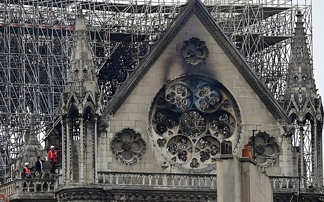 Des enquêteurs sur le toit de l'emblématique cathédrale Notre-Dame de Paris, le 16 avril 2019, au lendemain d'un incendie qui a ravagé son toit. (Lionel Bonaventure / AFP) Des enquêteurs sur le toit de l'emblématique cathédrale Notre-Dame de Paris, le 16 avril 2019, au lendemain d'un incendie qui a ravagé son toit. (Lionel Bonaventure / AFP)