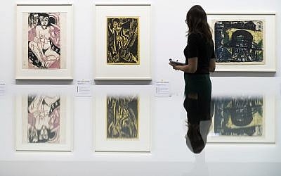 Une visiteuse observe les œuvres du peintre allemand Ernst Ludwig Kirchner présentées dans l'exposition "Collection Gurlitt, état des lieux, 'l'art dégénéré' – confisqué et vendu" du Kunstmuseum de Berne, en Suisse, novembre 2017. (Crédit : Peter Klaunzer/Keystone via AP)