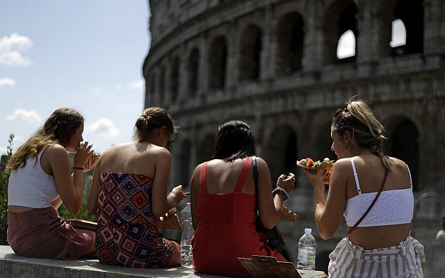 Des touristes assises devant le Colisée de Rome, juillet 2018. (Crédit : AP Photo/Gregorio Borgia)