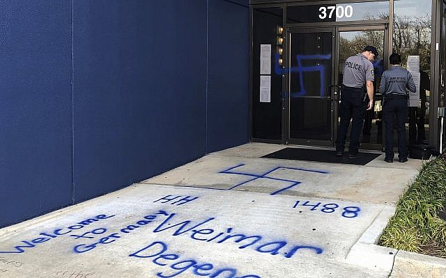 Les policiers sur les lieux d'un acte de vandalisme raciste et antisémite devant un bâtiment hébergeant le siège du Parti démocrate dans l'Oklahoma, le 28 mars 2019 (Crédit : AP Photo/Adam Kealoha Causey)