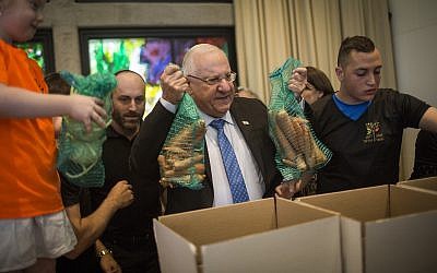 Le Président Reuven RIvlin aide des bénévoles à préparer des colis de nourriture pour les familles nécessiteuses avant Pessah, à la résidence du Président à Jérusalem, le 19 avril 2016. (Hadas Parush/Flash90/Fichier)