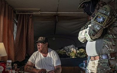 Larry Hopkins, assis, aussi connu sous le surnom de "Striker", chef de la milice United Constitutional Patriots opérant à la frontière américano-mexicaine, ici dans un campement à Anapra, au Nouveau-Mexique, le 20 mars 2019. (Crédit : Paul Ratje/AFP/Getty Images via JTA)