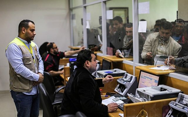 Des employés aident les Palestiniens à recevoir l'aide financière apportée par le Qatar aux familles défavorisées au bureau central de poste de Gaza City, le 26 janvier 2019 (Crédit : Mahmud Hams/AFP) Des employés aident les Palestiniens à recevoir l'aide financière apportée par le Qatar aux familles défavorisées au bureau central de poste de Gaza City, le 26 janvier 2019 (Crédit : Mahmud Hams/AFP)