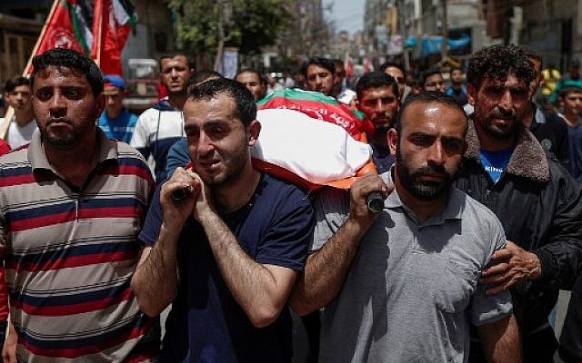 Des proches transportent le corps d'un Palestinien tué lors des frappes israéliennes la veille, durant des funérailles à Beit Lahia, dans le nord de la bande de Gaza, le 6 mai 2019 (Crédit : MAHMUD HAMS / AFP)
