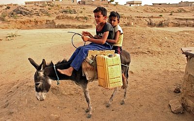 Des enfants yéménites transportent des bidons d'eau dans un camp au nord d'Abs, dans la province de Hajja, le 9 mai 2019; (Crédit : ESSA AHMED / AFP)