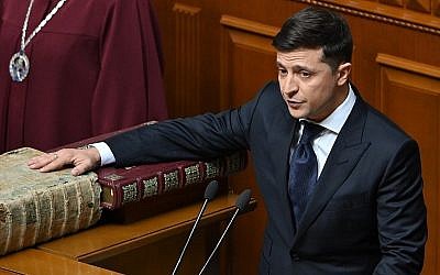 Le président ukrainien Volodymyr Zelensky prête serment sur la Bible et la constitution pendant la cérémonie d'investiture,à Kiev, le 20 mai 2019. (Crédit : Genya SAVILOV / AFP)