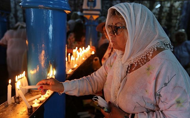 Une pèlerine juive allume une bougie le premier jour du pèlerinage annuel juif à la synagogue de la Ghriba, le plus ancien monument juif construit en Afrique, sur l'île balnéaire de Djerba, en Tunisie, le 22 mai 2019. (Crédit : FATHI NASRI / AFP)