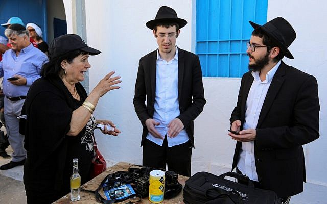Des lapins israéliens parlent devant la synagogue Ghriba le premier jour du pèlerinage juif annuel de la synagogue El Ghriba, le plus ancien monument juif construit en Afrique, sur l'île balnéaire de Djerba, en Tunisie, le 22 mai 2019. (Crédit :  FATHI NASRI / AFP)