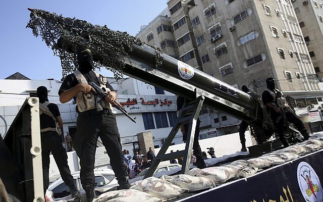 Des membres des brigades Al-Qods, la branche armée du Jihad islamique palestinien, avec un réplique d'une roquette durant une parade militaire, le 1 octobre 2018. (Crédit : AP/Adel Hana)