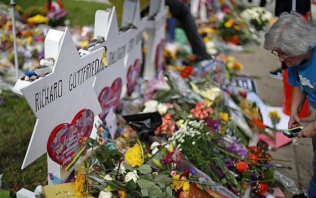 Une femme se recueille devant un mémorial de fortune à l'extérieur de la synagogue Tree of Life à Pittsburgh, en hommage aux 11 personnes tuées lors des offices religieux, le 31 octobre 2018. (Gene J. Puskar/ AP)