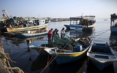 Des pêcheurs palestiniens nettoient un filet après une nuit de pêche, au port de Gaza, le 3 avril 2019. (Crédit : AP/Khalil Hamra) Des pêcheurs palestiniens nettoient un filet après une nuit de pêche, au port de Gaza, le 3 avril 2019. (Crédit : AP/Khalil Hamra)