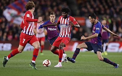 Antoine Griezmann et Thomas Partey, de l'Atlético et Sergio Busquets, (à droite) du FC Barcelone durant une match à Barcelone, le 6 avril 2019. (Crédit : AP Photo/Manu Fernandez) Antoine Griezmann et Thomas Partey, de l'Atlético et Sergio Busquets, (à droite) du FC Barcelone durant une match à Barcelone, le 6 avril 2019. (Crédit : AP Photo/Manu Fernandez)