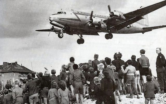 Des habitants de Berlin Ouest observent l’atterrissage d’un Rosinenbomber à Tempelhof, en 1948. (Domaine public) Des habitants de Berlin Ouest observent l’atterrissage d’un Rosinenbomber à Tempelhof, en 1948. (Domaine public)