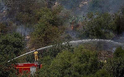 Des pompiers tentent d'éteindre un feu de forêt près de Mevaseret Zion, dans la périphérie de Jérusalem, le 22 mai 2019. (Crédit : Yonatan Sindel/Flash90)