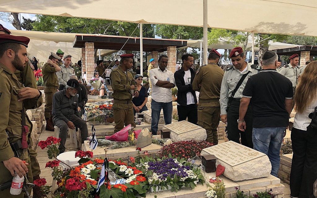 Les membres d'une famille en deuil devant la tombe de leur cher disparu au cimetière militaire d'Ashkelon à Yom HaZikaron, le 8 mai 2019 (Crédit : Jacob Magid/Times of Israel) Les membres d'une famille en deuil devant la tombe de leur cher disparu au cimetière militaire d'Ashkelon à Yom HaZikaron, le 8 mai 2019 (Crédit : Jacob Magid/Times of Israel)