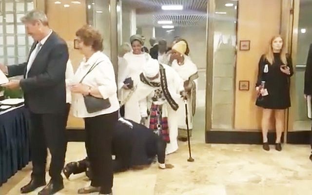 Le député Gadi Yevarkan embrasse les pieds de sa mère, au sol, en signe de gratitude, avant de prêter serment pour devenir officiellement membre de la 21e Knesset. (Crédit : capture d'écran Facebook)