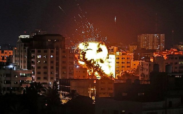 Image d'une explosion sur des immeubles lors d'une frappe israélienne à Gaza ville en riposte à des tirs de roquettes depuis l'enclave palestinienne le 4 mai 2019. 
(Crédit : Mahmud Hams / AFP)