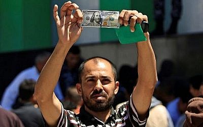 Un Palestinien montre un billet de 100 dollars reçu dans le cadre de l'aide de 480 millions de dollars allouée par le Qatar à la bande de Gaza, le 13 mai 2019.(MOHAMMED ABED / AFP)