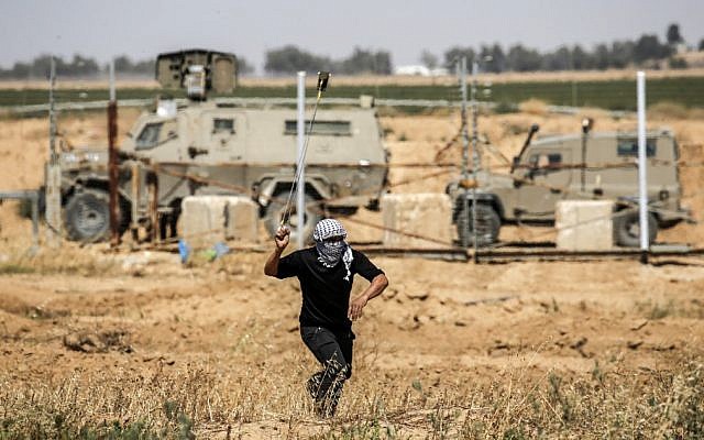 Un émeutier palestinien utilise une fronde pour lancer une pierre sur les soldats israéliens lors des manifestations de la Journée de la Nakba à l'est de Khan Younis dans le sud de la bande de Gaza, le 15 mai 2019. (Thomas COEX / AFP) Un émeutier palestinien utilise une fronde pour lancer une pierre sur les soldats israéliens lors des manifestations de la Journée de la Nakba à l'est de Khan Younis dans le sud de la bande de Gaza, le 15 mai 2019. (Thomas COEX / AFP)
