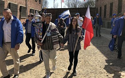 Edward Mosberg, tenant un rouleau de la Torag, lors d'une Marche des Vivants en 2018 dans l'ancien camp de la mort d'Auschwitz en Pologne. (Crédit Des profondeurs).