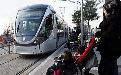 Une femme palestinienne et ses enfants attendent le tramway dans le quartier arabe de Shuafat dans le nord de Jerusalem.  (Crédit: Sliman Khader/Flash90)