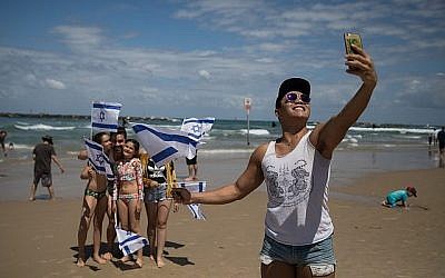 Des gens regardent la démonstration aérienne de l'Armée de l'Air israélienne pour Yom HaAtsmaout à la plage Bugrashov de Tel Aviv, le 9 mai 2019.(Hadas Parush/Flash90)