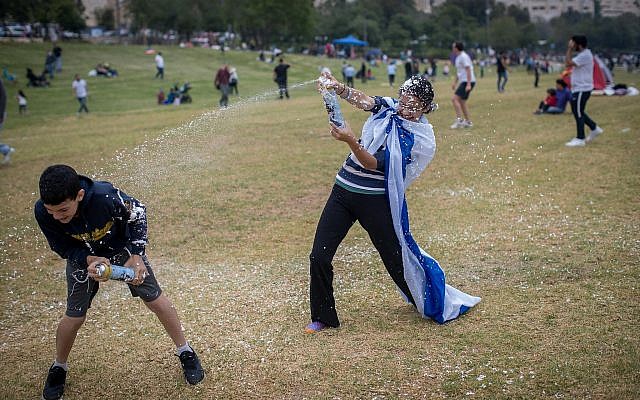 Des Israéliens s'aspergent de mousse alors qu'ils fêtent le 71ème Jour de l'Indépendance à Jérusalem le 9 mai 2019. 
(Yonatan Sindel/Flash90)