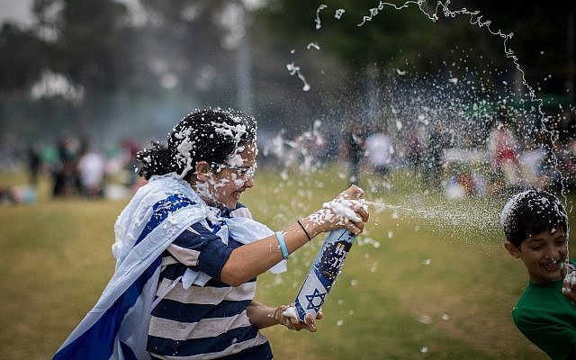Des Israéliens s'aspergent de mousse alors qu'ils fêtent le 71ème Jour de l'Indépendance à Jérusalem le 9 mai 2019. 
(Yonatan Sindel/Flash90)