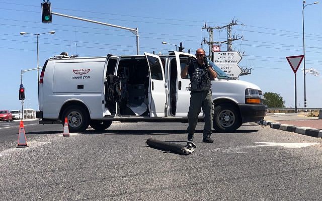 Un démineur de la police est vu près d'une roquette qui a atterri sur la route 4, une route principale près d'Ashkelon (Crédit : police israélienne) Un démineur de la police est vu près d'une roquette qui a atterri sur la route 4, une route principale près d'Ashkelon (Crédit : police israélienne)