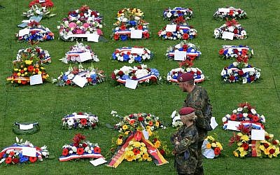 Des soldats allemands devant les gerbes de fleurs au cimetière militaire allemande à la Cambe, le 5 juin 2019. (Crédit : JEAN-FRANCOIS MONIER / AFP)