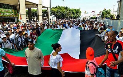Des manifestants scandent des slogans et agitent un drapeau palestinien géant lors d'une manifestation à Rabat, la capitale marocaine, le 23 juin 2019 contre la conférence économique organisée à Bahreïn par les États-Unis. (Crédit photo : AFP) Des manifestants scandent des slogans et agitent un drapeau palestinien géant lors d'une manifestation à Rabat, la capitale marocaine, le 23 juin 2019 contre la conférence économique organisée à Bahreïn par les États-Unis. (Crédit photo : AFP)