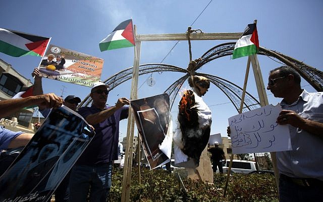 Des Palestiniens brûlent un mannequin à l'effigie de Donald Trump à Bethléhem pour protester contre le sommet à Bahreïn sur le volet économique du plan de paix proposé par l’administration Trump, le 25 juin 2019. (Crédit :  Al SHAER / AFP)