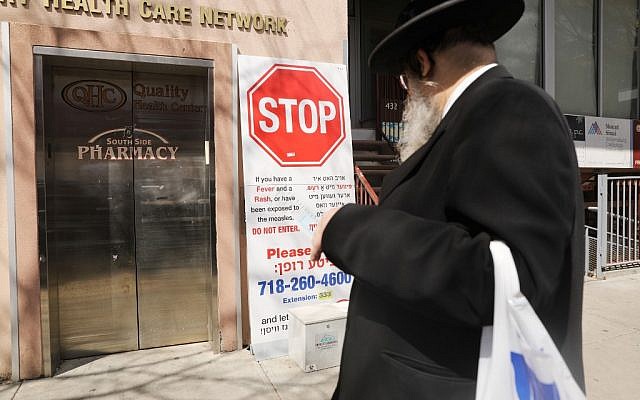 Un panneau mettant en garde la communauté juive ultra-orthodoxe contre une épidémie de rougeole devant une parmacie du quartier de Williamsburg, le 10 avril 2019. (Crédit : Spencer Platt/Getty Images/AFP) Un panneau mettant en garde la communauté juive ultra-orthodoxe contre une épidémie de rougeole devant une parmacie du quartier de Williamsburg, le 10 avril 2019. (Crédit : Spencer Platt/Getty Images/AFP)