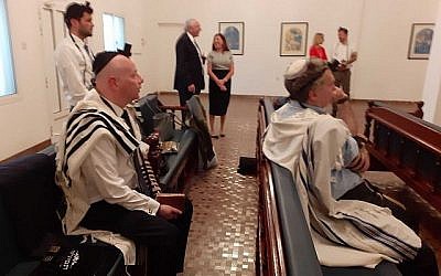 Les fidèles, parmi lesquels Jason Greenblatt, envoyé de l'administration Trump au Moyen-Orient,à gauche, assis, lors de la prière du matin dans une synagogue de Manama, au Bahreïn, le 26 juin 2019 (Crédit : Raphael Ahren/Times of Israel)
