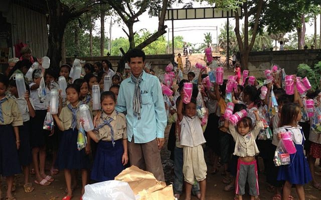 Arun Sothea dirige un orphelinat au Cambodge avec l'aide d'organisations caritatives juives. Ici, il distribue des fournitures aux petites filles dans son village de Phum Thom (Autorisation : Arun Sothea)