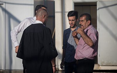 L'avocat Nashaf Darwish (g) parle avec le frère et le fils de Mahmoud Qadusa, un Palestinien suspecté du rapt et du viol du fillette israélienne de 7 ans, devant un tribunal militaire de Cisjordanie, le 19 juin 2019. (Crédit : Yonatan Sindel/Flash90)
