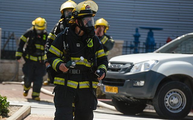 Les pompiers israéliens sur la scène d'une fuite d'ammoniaque à proximité d'un centre commercial d'Acre, le 27 juin 2019 (Crédit : Meir Vaknin/Flash90)