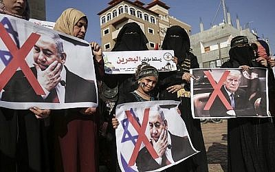 Des supportrices palestiniennes du groupe terroriste Jihad islamique portent des pancartes du président américain Donald Trump et du Premier ministre Benjamin Netanyahu lors d'une manifestation contre l'atelier économique du Bahreïn dans le sud de la bande de Gaza à Rafah, le 18 juin 2019. (SAID KHATIB / AFP)