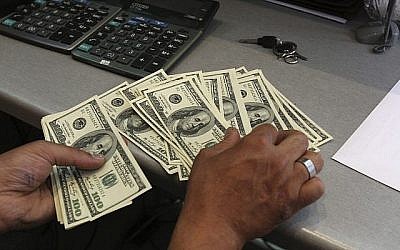 Un employé d'un bureau de change compte des dollars américains dans le centre-ville de Téhéran, en Iran, le 9 juin 2011. (AP/Vahid Salemi)