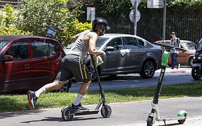 Un utilisateur de trottinette électrique dans les rues de Tel Aviv, le 30 mai 2019. (Crédit : JACK GUEZ / AFP)