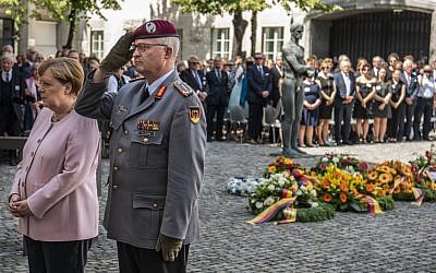 La chancelière allemande Angela Merkel (à gauche) et l'inspecteur général des forces armées allemandes, Eberhard Zorn, se tiennent devant une plaque après avoir déposé une gerbe de fleurs lors de la cérémonie commémorative du 75e anniversaire de la tentative d'assassinat d'Adolf Hitler à Berlin, le 20 juillet 2019. (JOHN MACDOUGALL / AFP)